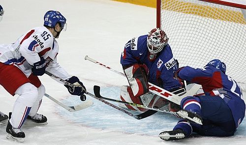 Slovenský gólman Karol Križan likviduje pokus Rostislava Olsze (v bílém). Vrpavo leží Richrad Kapuš. | Foto: Reuters