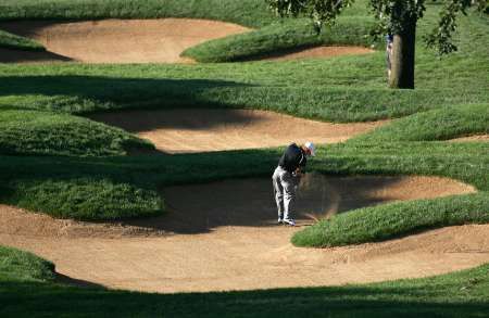 Australský golfista Adam Scott odpaluje z bunkru na páté fairwayi třetího dne šampionátu PGA v Medinahu. | Foto: Reuters