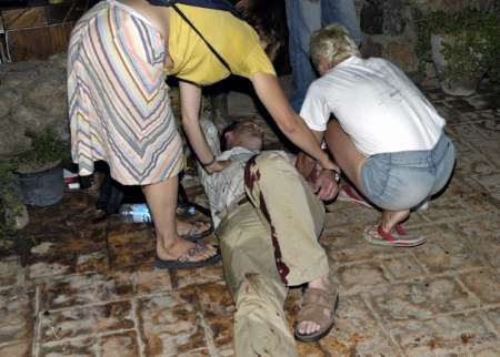 Turisté pomáhají jednomu z více než šest desítek zraněných. | Foto: Reuters