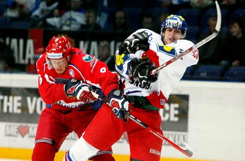 Anton Bělov z Ruska (vlevo) a český útočník Miroslav Blaťák bojují o puk. | Foto: Reuters