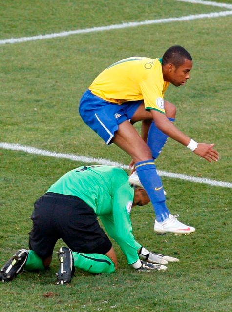 Brazilec Robinho v návalu radosti po vstřelení druhé branky do sítě USA na poháru FIFA přeskakuje překonaného brankáře Howarda. | Foto: Reuters