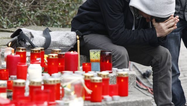 Před budovu školy nosí lidé svíčky a květiny. | Foto: Reuters