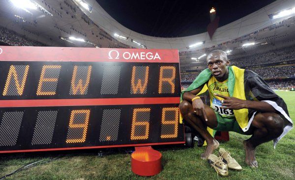 Usain Bolt pózuje u tabule s hodnotou nového světového rekordu. | Foto: Reuters