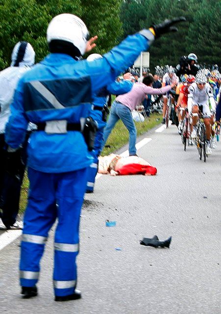 Smrtelná nehoda na Tour de France - žena ležící v červeném zemřela po srážce s motorkou | Foto: Reuters