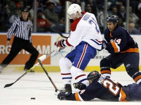 Centr Montrealu Christopher Higgins se v utkání NHL snaží uniknout dvěma bekům newyorských Islanders Radku Martínkovi (na ledě) a Chrisu Campolimu. | Foto: Reuters