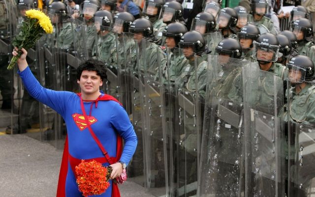 Mezi demonstranty, kteří protestují proti zasedání Světové obchodní organizace WTO v Hong Kongu, se zapojil i Superman. Tedy přesněji muž, který se oblékl do kostýmu legendárního komiksového hrdiny. | Foto: Reuters