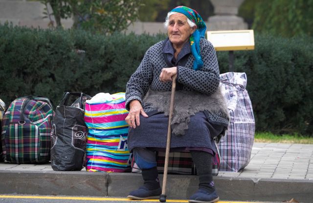 Někteří lidé ale přece jen zůstali. "Když tam nebudeme bydlet my, tak kdo?" ptá se jedna z dvojice žen. "Říkáme všem, aby se vrátili. Aby se vrátili zpět do svých domovů," doplňuje ji druhá s tím, že se na rozdíl od ostatních nebojí bydlet s Ázerbájdžánci. "Nedokážeme říct, jaké to bude, dokud to nezažijeme," říkají. Do Stěpanakertu se po ukončení bojů vrací i tato žena na fotografii. | Foto: ČTK/AP/Dmitri Lovetsky