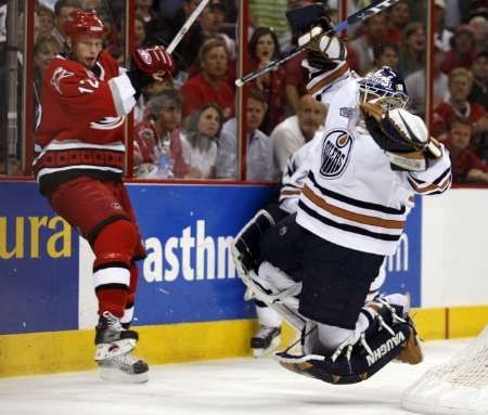 Eric Staal z Caroliny u hrazení tvrdě atakuje edmontonského brankáře Jussi Markkanena. | Foto: Reuters