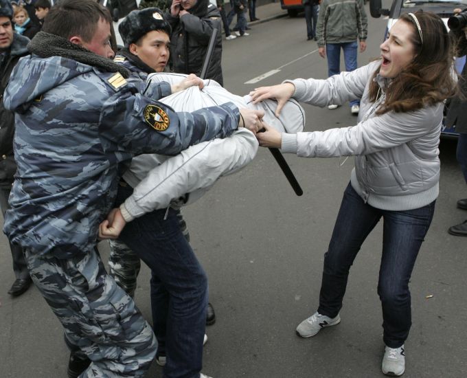 Ruští policisté zatýkají jednoho z mnoha zatčených nacionalistů během nepovoleného "ruského marše" | Foto: Reuters