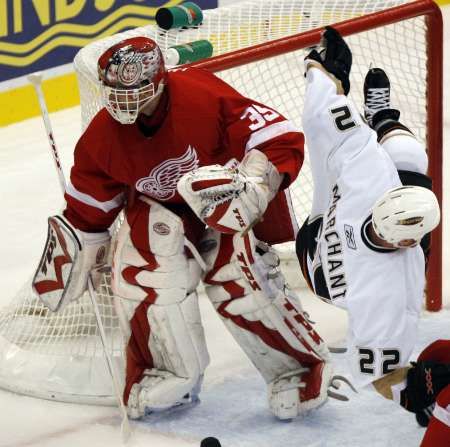 Hokejita Anaheimu Todd Marchant padá do branky detroitského Dominika Haška v nedělním semifinále play off NHL. | Foto: Reuters