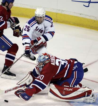 Petr Průcha z New Yorku Rangers (v bílém) se snaží dorazit kotouč za záda montrealského gólmana Davida Aebischera. | Foto: Reuters