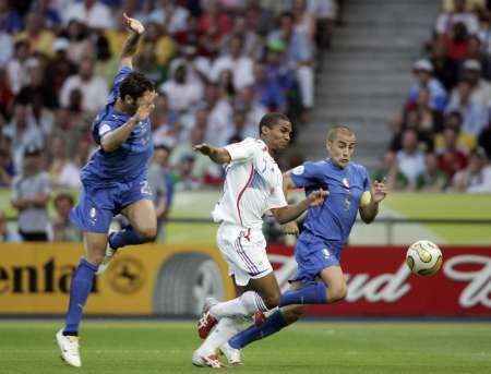 Francouz Florent Malouda (v bílém) padá mezi italskými hráči Marco Materazzim (vlevo) a Fabio Cannavarem. Za tento zákrok byla nařízena penalta. | Foto: Reuters