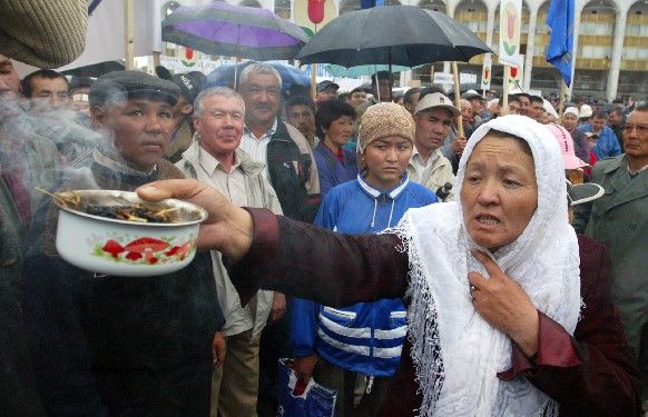 Kyrgyzská žena drží hrnec s hořícími vonnými tyčinkami na znamení dobré vůle, během nedělní demonstrace na hlavním náměstí Ala-Too v Biškeku. | Foto: Reuters