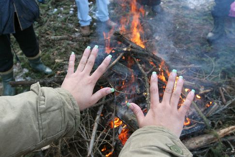 During a short break it is time to warm up at the fire. Monika Demeterová takes off her gloves and reveals her well-cared for nails. Trained as a shop assistant, she could not find a job as one: "It's enough if I introduce myself and they don't have any vacancies. When my Czech boyfriend calls, they do." | Foto: Ondřej Besperát