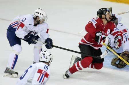 Kanaďan Martin St. Louis (vpravo) padá po zákroku Slovince Roka Pajice (vlevo) v utkání MS v Halifaxu. | Foto: Reuters