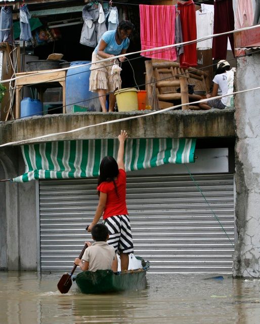 Lidé v Binan Laguna na jih od Manily si kupují zboží ve druhém patře obchodu, který částečně zaplavila povodeň. | Foto: Reuters