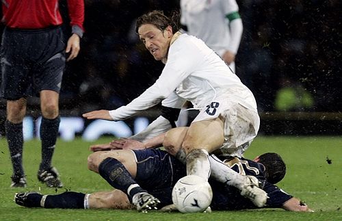 Ital Massimo Ambrosini (v bílém) tvrdě bojuje o míč se Skotem Barry Fergusonem. | Foto: Reuters