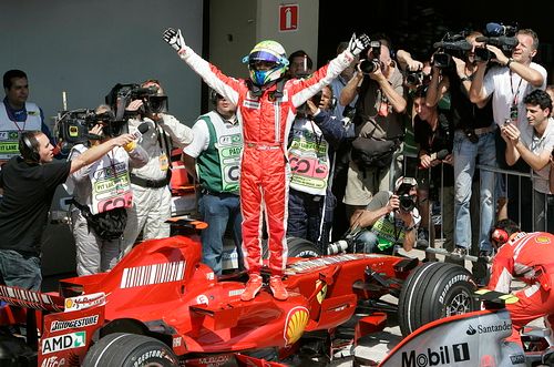 Felippe Massa stojí na svém Ferrari, oslavuje pole position v domácí Velké ceně Brazílie. | Foto: Reuters