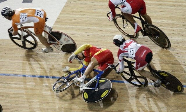 Čínský cyklista Qi Tang (vlevo) padá pod kola Kanaďana Travise Smithe v kvalifikaci keirinu na MS dráhových cyklistů. | Foto: Reuters