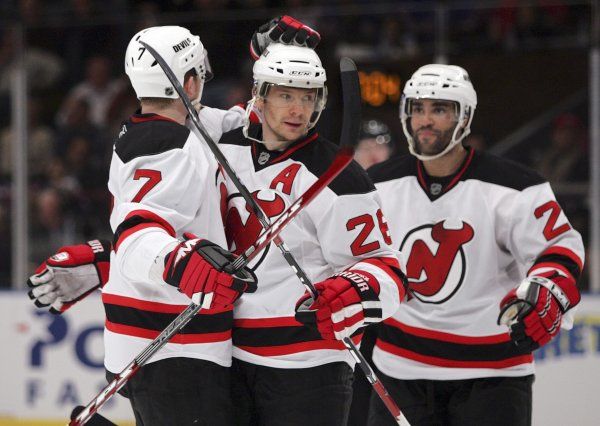 Paul Martin (vlevo) a Johnny Oduya (vpravo) gratulují Patriku Eliášovi ke gólu do sítě New York Rangers. | Foto: Reuters