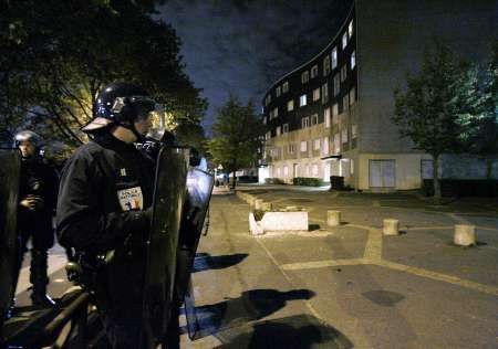 Grigny - Franouzská policejní hlídka poblíž obytné budovy v Grigny na jihu Paříže, 11.noc nočních nepokojů. Prezident Chirac vyzval k obnovení pořádku v zemi, poté co se nepokoje rozšířily po celé Francii. (Reuters) | Foto: Reuters