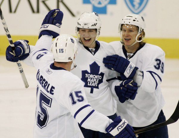 Tomáš Kaberle a Simon Gamache gratulují Jiřímu Tlustému (uprostřed) ke gólu ještě v dresu Maple Leafs. | Foto: Reuters