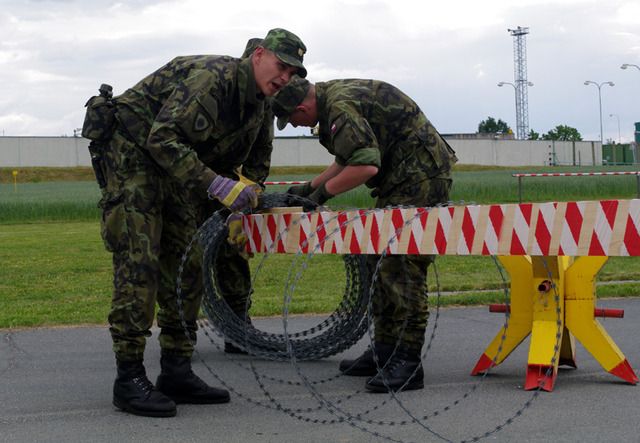 Na zátarasy navlékají příslušníci aktivní zálohy kola žiletkového drátu | Foto: Aktuálně.cz