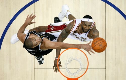 Tim Duncan ze San Antonia (vlevo) blokuje akci clevelandského LeBrona Jamese. | Foto: Reuters