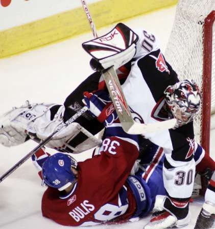 Brnakář Buffala Ryan Miller padá na montralského útočníka Jana Bulise. | Foto: Reuters