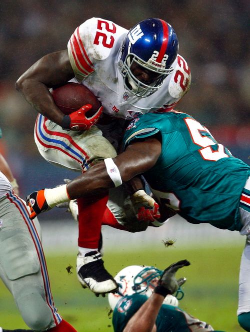 Reuben Droughns z New Yorku Giants (vlevo) je atakovaný hráčem Miami Dolphins Donnie Spragnanem. Zámořská NFL poprvé v historii zamířila do Evropy, hrálo se ve Wembley. | Foto: Reuters