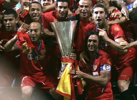 Fotbalisté FC Sevilla s trofejí pro vítěze Poháru UEFA. | Foto: Reuters