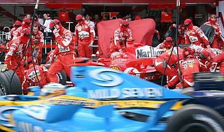 Fernando Alonso s Renaultem (vpředu) projíždí kolem boxů Ferrari svého rivala v boji o titul Michaela Schumachera. | Foto: Reuters