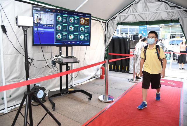 Studentům při vstupu do školy měří technologie na rozpoznávání obličejů teplotu. | Foto: ČTK/Xinhua/Ren Chao