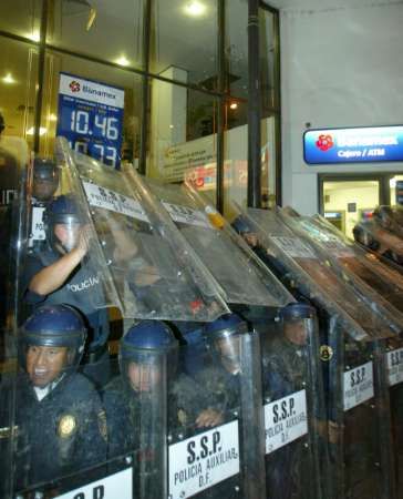 Polisté brání vstup do banky, na kterou zaútočili demonstranti u příležitosti Světového fóra o vodě. | Foto: Reuters