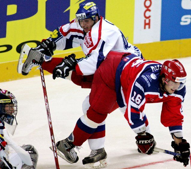 Miroslav Blaťák bojuje s Rusem Alexejem Škotovem před brankářem Romanem Málkem na libereckém turnaji Euro Hockey Tour. | Foto: Reuters