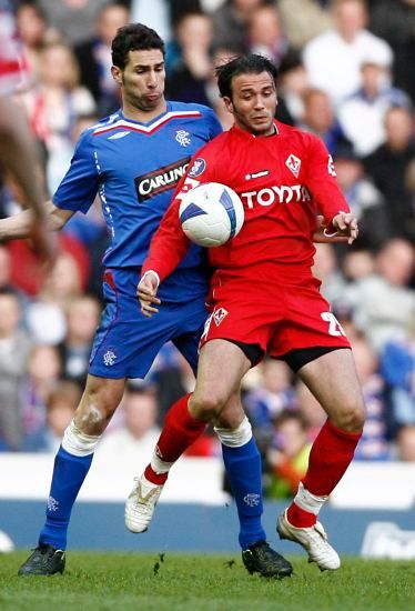 Giampaolo Pazzini (vpravo) si kryje míč před Carlosem Cuellarem z Glasgow Rangers. | Foto: Reuters