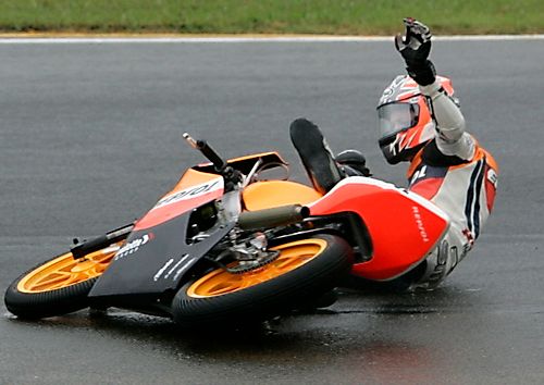 Britský jezdec Bradley Smith padá se svojí Hondou v závodě třídy do 125 ccm v Motegi. | Foto: Reuters