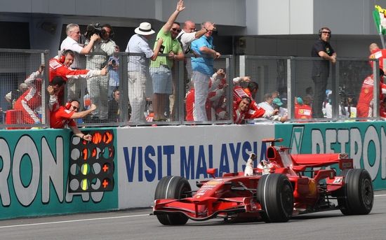 Kimi Räikkönen s Ferrari zajíždí k mechaniků a oslavuje prvenství v Malajsii. | Foto: Reuters