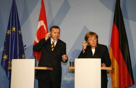 German Chancellor Angela Merkel and Turkish Prime Minister Tayyip Erdogan (L) adjust earphones as they listen to a journalist's question during a brief news conference following a meeting at the guesthouse of Lower Saxony's Government in Hanover April 15, 2007. Merkel and Erdogan will open the "Hannover Messe" industrial trade fair on Sunday and Turkey is this year's partner country. The world's leading fair for industrial technology with about 6,400 exhibitors from 62 nations opens to the public on Monday and runs till April 20 showing their latest products and technical innovations. REUTERS/Christian Charisius (GERMANY | Foto: Reuters