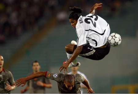 Hráč AS Řím Matteo Ferrari a fotbalista Shakhtaru Donetsk Brandao (nahoře) skáčí po míči v utkání Ligy mistrů skupiny D. | Foto: Reuters