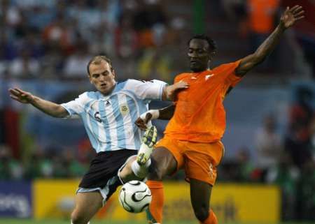 Argentinec Esteban Cambiasso (vlevo) a Didier Zokora z Pobřeží Slonoviny bojují o míč. | Foto: Reuters