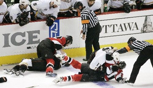 Ottawský Peter Schaefer (na ledě v červeném) v potyčce s Dustinem Pennerem z Anaheimu, nahoře se pere Mike Fischer s dalším hráčem Kačerů. | Foto: Reuters