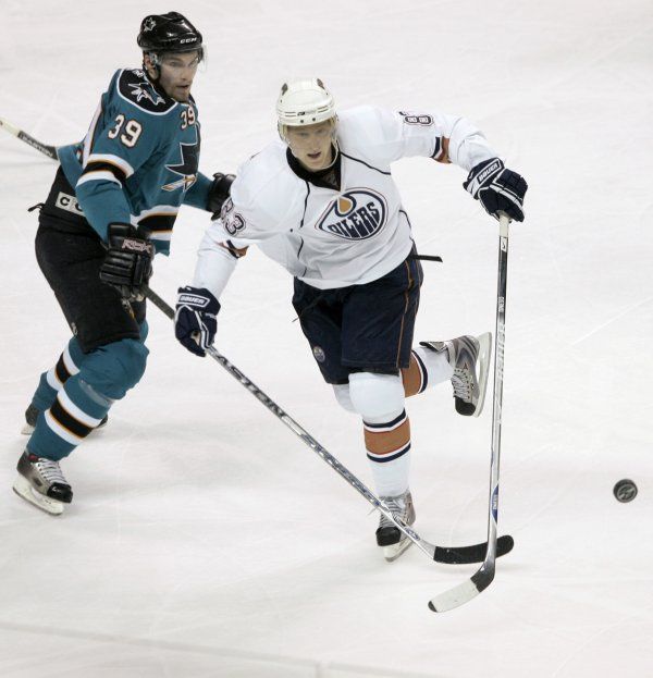 Aleš Hemský z Edmontonu (v bílém) obchází krajana v dresu San Jose Tomáše Plíhala. | Foto: Reuters