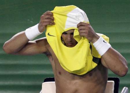 Španělský tenista Rafael Nadal si mění v průběhu zápasu prvního kola Australian Open proti Američanu Kendrickovi propocené tričko. | Foto: Reuters