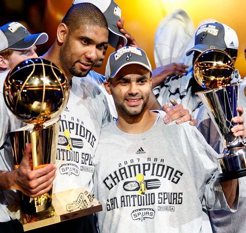 Tim Duncal (vlevo) a Tony Parker drží v rukou trofeje po vítězství San Antonia ve finále NBA. | Foto: Reuters