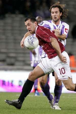 Fotbalista Toulouse Gilles Pantxi-Siriex v souboji se spaťanem Miroslavem Slepičkou v utkání poháru UEFA. | Foto: Reuters