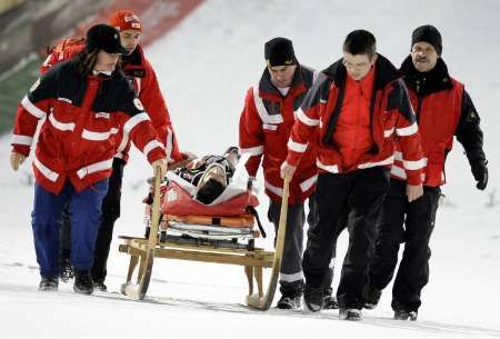 Rakouský skokan Adreas Kofler byl převezen z můstku hned do sanitky | Foto: Reuters