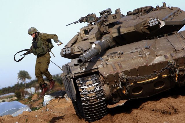 Izraelský voják vyskakuje z tanku na severu pásma Gazy. | Foto: Reuters