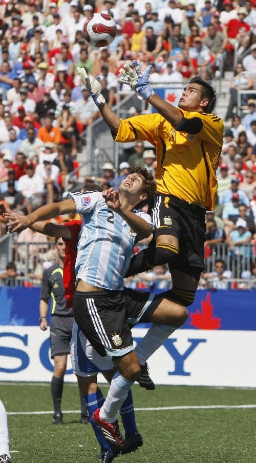 Argentinský brankář Romero (vpravo) likviduje vysoký míč, před ním skáče spoluhráč Federico Fazio. | Foto: Reuters