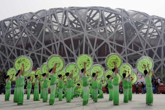 Taneční představení před pekingským stadiónem u příležitostí oslav 100 dní, zbývajících do začátku olympiády. | Foto: Reuters